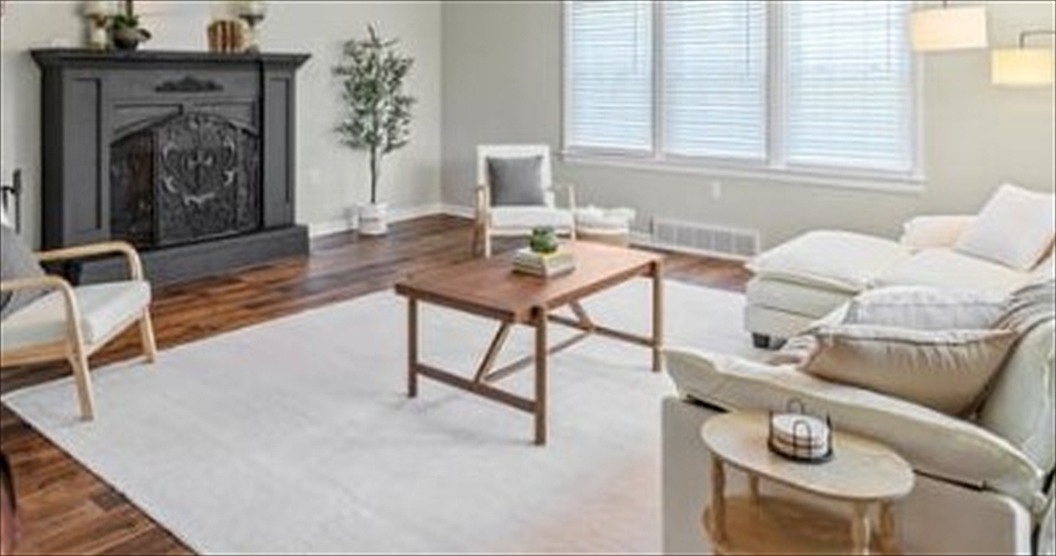 Living room styled in warm neutrals around a black fireplace